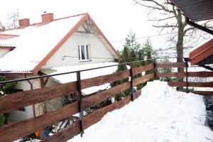 a pile of snow on a fence in front of a house at Apartament Gorki Male in Tuszyn