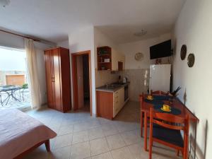 a small kitchen with a table and a refrigerator at Olive garden Pag studio apartment in Pag