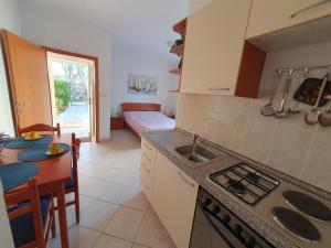 a kitchen with a sink and a table with a dining room at Olive garden Pag studio apartment in Pag
