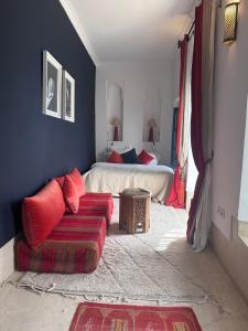 - une chambre avec un lit et un canapé rouge dans l'établissement Berber Duchess Riad, à Marrakech
