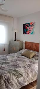 薩拉戈薩的住宿－Suite Lay，卧室内的一张床铺,墙上有绘画作品