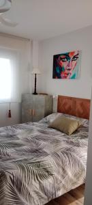 a bed in a bedroom with a painting on the wall at Suite Lay in Zaragoza +9 photos