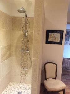 a shower with a chair next to a shower at Atelier Soleil in Moustiers-Sainte-Marie