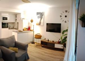 a living room with a couch and a clock on the wall at Suite Lay in Zaragoza