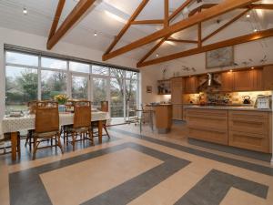 eine Küche mit Tisch und Stühlen und einem großen Fenster in der Unterkunft Valley Farm Cottage in Woodbridge