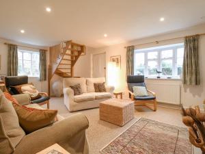 a living room filled with furniture and a staircase at Valley Farm Cottage in Woodbridge