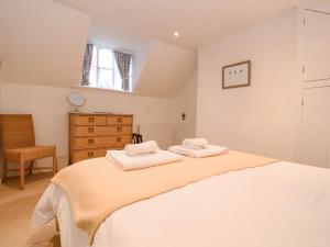 a bedroom with a large bed with two towels on it at Valley Farm Cottage in Woodbridge