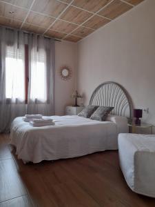 a bedroom with two beds with white sheets and wood floors at Vivienda Turistica Vino Tinto in Almonacid de Toledo