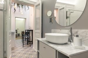 a bathroom with a sink and a large mirror at Residenze Florio in Catania
