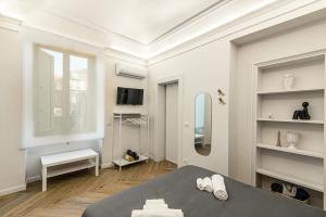 a white room with a bed and a mirror at Residenze Florio in Catania