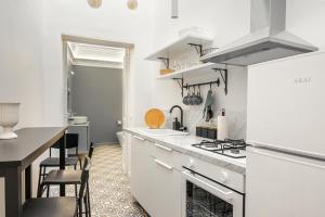 a kitchen with white counters and a stove top oven at Residenze Florio in Catania