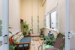 ein Wohnzimmer mit zwei Stühlen und einem Fenster in der Unterkunft Casa charmosa e confortável no Porto Maravilha - quartos disponíveis conforme número de hóspedes in Rio de Janeiro