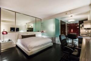 ein Schlafzimmer mit einem Bett und einem Schreibtisch sowie eine Küche in der Unterkunft Palms Place Hotel by Orgoto in Las Vegas