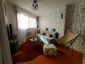 a living room with a blue couch and a tv at Maisonnette au cœur des Angles in Les Angles