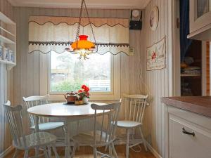 una mesa y sillas en una cocina con ventana en Holiday home Brastad X, en Brastad