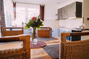 a dining room table with a vase of flowers on it at Ferienwohnung Im Schafftl 10 in Ramsthal