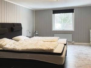 Holiday home BENGTSFORS VIII في بينغتسفورس: سرير كبير في غرفة نوم مع نافذة