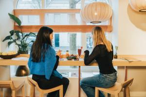 zwei Frauen an einer Theke in einer Küche in der Unterkunft Eclectic Hotel Copper in Middelburg