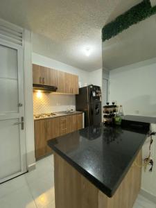 Apartamento en Cartagena في كارتاهينا دي اندياس: مطبخ مع كونتر اسود توب وثلاجة