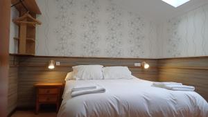 a bedroom with a bed with two towels on it at Pensión O Escondidino in Baiona