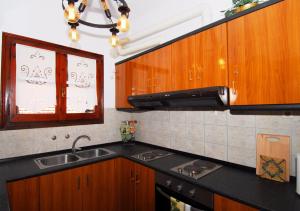 a kitchen with wooden cabinets and a sink and a window at Athina-Milina in Milina +63 photos