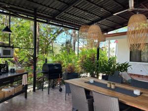 a patio with a table and chairs and some plants at La Jungla in Carrillo