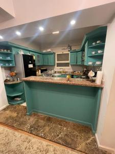 a kitchen with green cabinets and a counter top at Apartment for rent in Ramo 6 October in 6th Of October