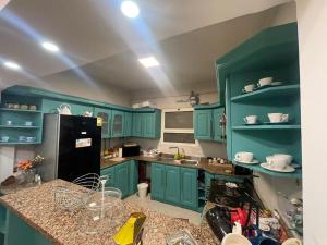 a kitchen with green cabinets and a black refrigerator at Apartment for rent in Ramo 6 October in 6th Of October