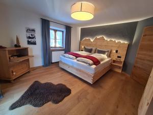 Schlafzimmer mit einem großen Bett mit einem Kopfteil aus Holz in der Unterkunft das Alpen Natur Idyll in Grainau