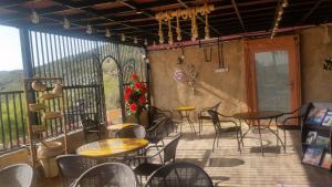 un patio con mesas y sillas en el balcón en Durrat Al-Misfah Guest House, en Misfāh
