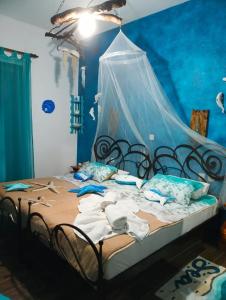 1 dormitorio con 1 cama con pared azul en Athina-Milina en Milína