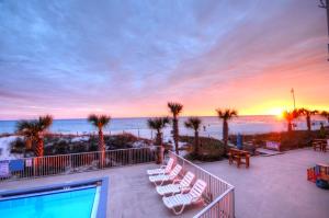 a balcony with chairs and a swimming pool and the ocean at Starfish Villa in Panama City Beach