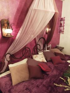 een slaapkamer met een hemelbed bij Athina-Milina in Milína