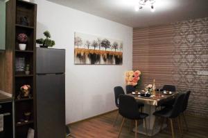 a dining room with a table and a refrigerator at ERAS - Топ център Варна in Varna City +31 photos