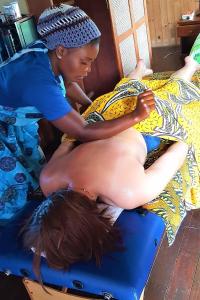 een vrouw die een rugmassage krijgt op een bed bij Venha Juntos Guest Homes in Miramar
