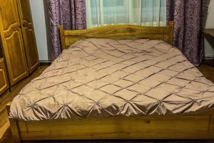 a wooden bed in a room with a window at Pensiunea Brezu in Sighetu Marmaţiei