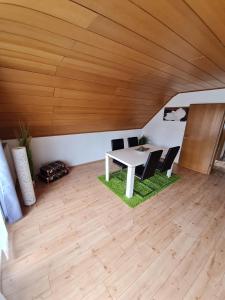 einen Tisch und Stühle in einem Zimmer mit Holzdecke in der Unterkunft Ferienwohnung mit toller Aussicht in Albstadt