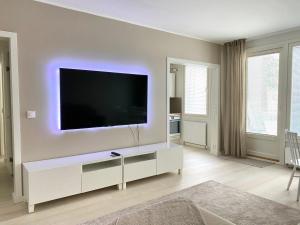 a living room with a flat screen tv on a wall at City Apartment Sotilaskatu in Iisalmi