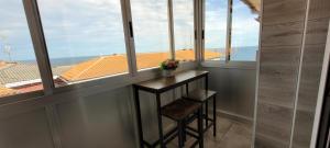 Una mesa pequeña con dos taburetes en una habitación con ventanas. en Arribolas, en Bermeo 21 fotos más