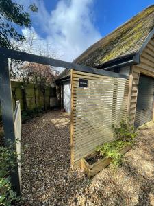 a wooden privacy fence in front of a house at The Annexe - woodland views and close to beach! in Barton on Sea