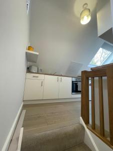 a kitchen with white cabinets and a stove at The Annexe - woodland views and close to beach! in Barton on Sea