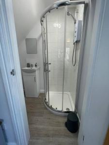 a shower with a glass door in a bathroom at The Annexe - woodland views and close to beach! in Barton on Sea