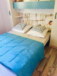 - une chambre avec un lit doté de draps et d'oreillers bleus dans l'établissement Beach house à Marina di Sorbo …Corse, à Sorbo-Ocagnano