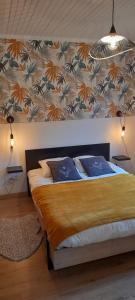 een slaapkamer met een groot bed met een muur bij Chalet de l'Ours Brun, gîte 3 étoiles in Gère-Belesten