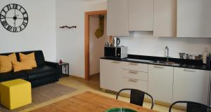 a kitchen with a couch and a table in a room at RivApartmentsDowntowN Urban in Riva del Garda