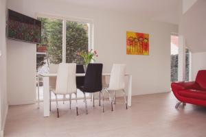 une salle à manger avec une table et des chaises blanches dans l'établissement VacationVilla Noordwijk, à Noordwijk