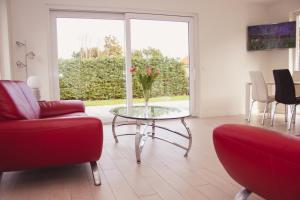 un salon avec une table avec un vase de fleurs dessus dans l'établissement VacationVilla Noordwijk, à Noordwijk 27 autres photos