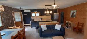 a living room with a couch and a kitchen at Chalet de l'Ours Brun, gîte 3 étoiles in Gère-Belesten
