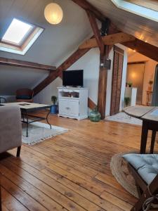 a living room with wooden floors and a ceiling with beams at Quai 2 voie C 