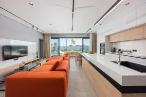 a living room with orange chairs and a kitchen at Villa Milo in Side